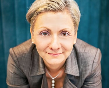 a woman in a suit and a necklace