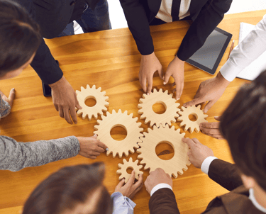 a group of people standing around a table with gear