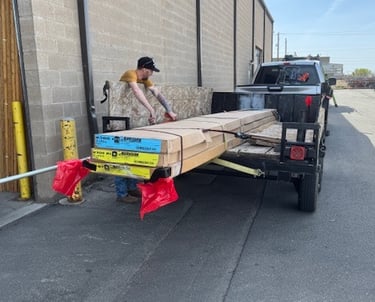 a man is loading a carton of wood planks