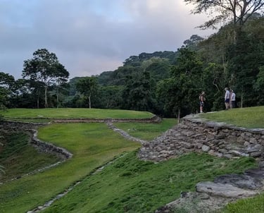 Tourists exploring the stone terraces and circular ruins of Ciudad Perdida in the Colombian jungle.