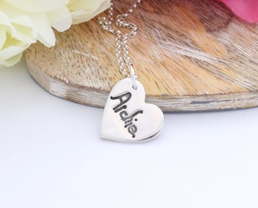 Your childs name, written by them, pressed onto a silver heart pendant