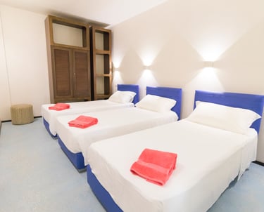 a bedroom with three beds and a television