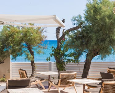 a patio with a table and chairs and a view of the ocean
