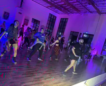 A group of 22 dancers actively posed in a dance move.