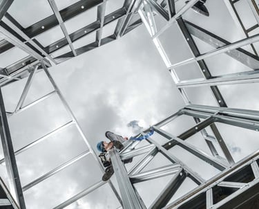 a man on a ladder with a ladder in the middle of a metal structure