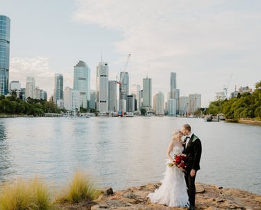 a bride and groom standing on a rock wall in Kangaroo Cliffs