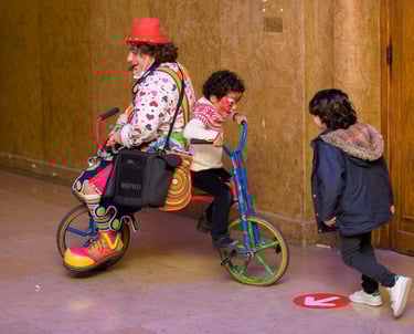 clown avec un chapeau rouge et un vélo d'enfant