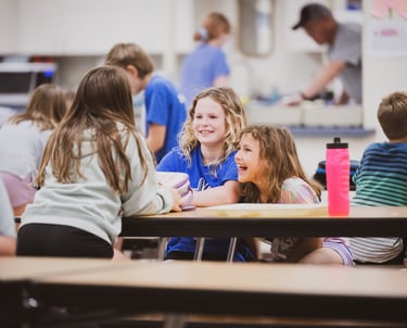a group of children and adults sitting at a table