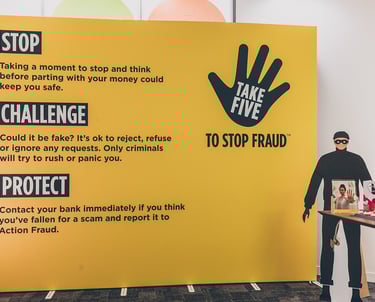 a cardboard thief standing in front of a large yellow banner