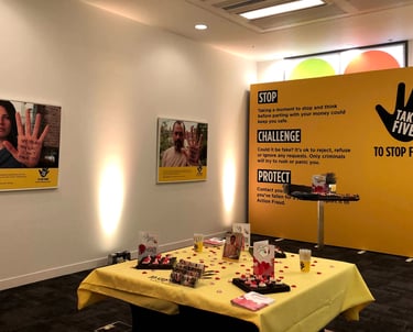 a room with a large banner, posters and a table 