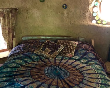 interior view of round house holiday let showing a double bed with a blue mandala bed cover