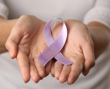 lavender cancer ribbon in woman's hands
