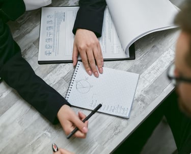 a man and woman sitting at a table with notebooks