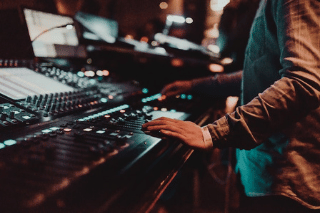 a man in a blue shirt is playing with a sound board