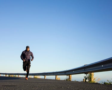 un homme court sur la route près d'une barrière de sécurité