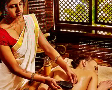 Una donna sdraiata sul lettino da massaggio che riceve un trattamento ayurvedico