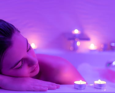 Close up Low light portrait of young woman relaxing in foam bath.Low colorful candlelight ambient wi