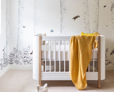 a baby's nursery with a beautiful jungle themed wallpaper 