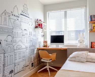 a small bedroom with bespoke headboard attached to a desk with maximised storage 
