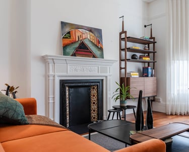 a study with a fireplace and a couch - mid-century modern vibes