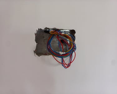 Exposed colorful electrical wires in a metal wall junction box during home renovation.