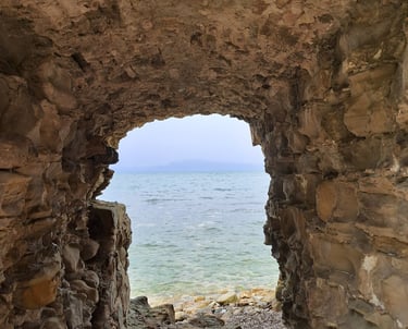 a stone archway leading to the ocean