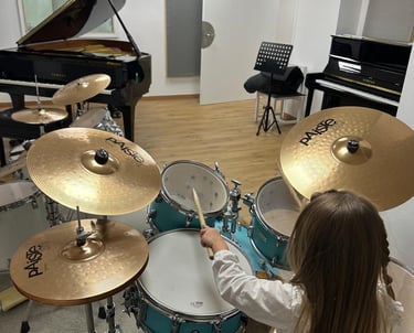 a young girl playing drums in a music school