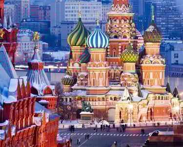 Saint Basil's Cathedral in Moscow's Red Square with colorful onion domes covered in winter snow.
