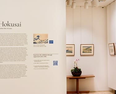 Exhibition installation image of Hokusai: Another Side of Genius that shows the wall text and prints