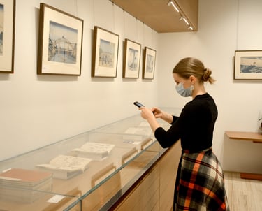 Madison looking at illustrated books by Hokusai in the vitrine