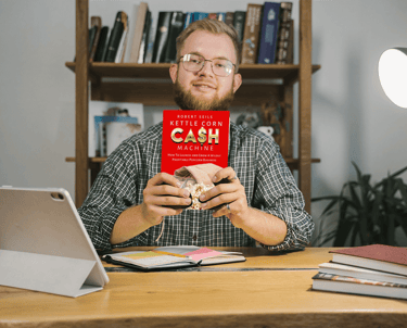 a man sitting at a desk with a book about cash