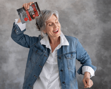 older woman holding the sourdough starter guide book