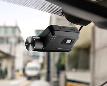 Thinkware dash cam mounted on car windscreen for smart driving video recording and safety.