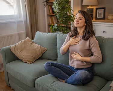 A woman practicing mindfulness and deep breathing exercises while in therapy