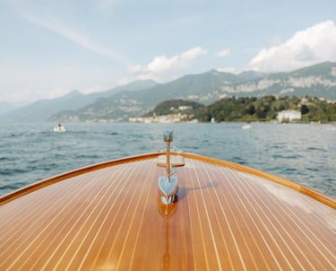 a boat on the water with a view of mountains in the background in lake como