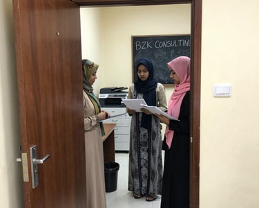 A friendly consultant assisting a Turkish client with visa paperwork in an office setting.