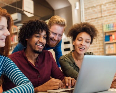 a group of people sitting around a laptop computer
