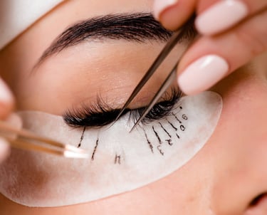 eyelash extension professional applying eyelash extensions, client has lash map under eye