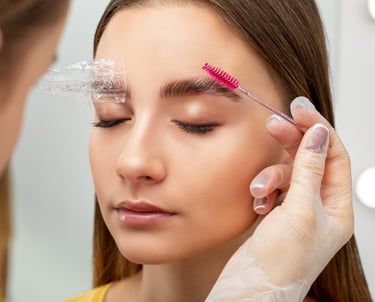 professional brushing clients eyebrow after brow lamination treatment