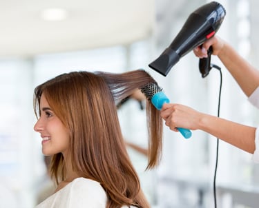 Woman getting her hair blow-dried by hairdressers in Bournemouth salon