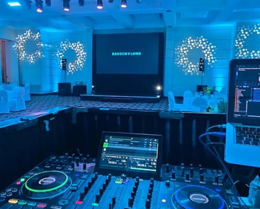 DJ profesional en funcionamiento con iluminación LED azul en evento corporativo