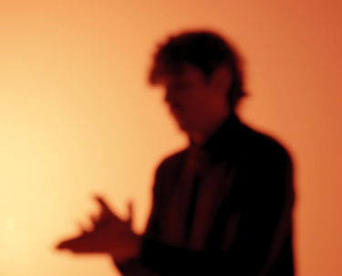 Al-Blanco in a suit and tie is singing a bambera