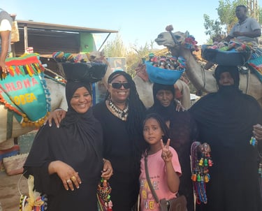 Davida Roze in Aswan egypt with Nubia women and men on camels