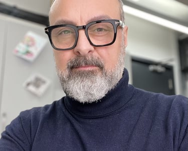 a man with a beard and glasses on a desk