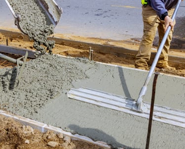 a man is pouring concrete into a concrete slab