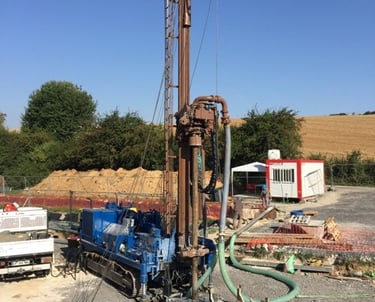 a drilling rig with a drilling machine in the background