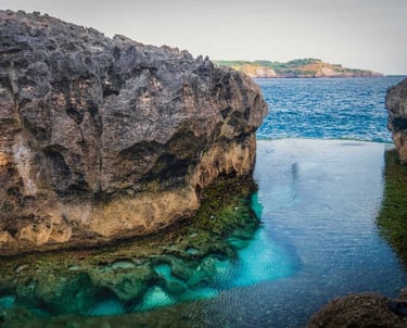Angel's Billabong in Nusa Penida, Bali, featuring a natural rock infinity pool with clear turquoise water.