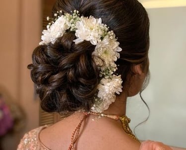 Elegant bridal bun decorated with white flowers for a wedding hairstyle