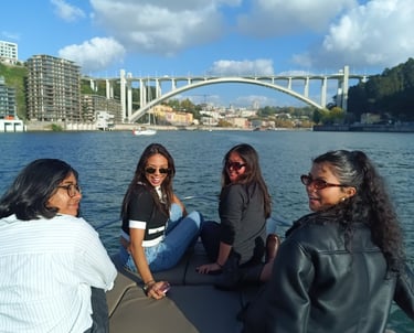 Enjoying a scenic private boat tour on the Douro River in Porto with Arrabida Bridge in background.
