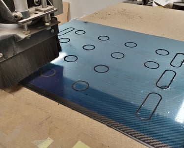 a machine is cutting through a piece of carbon fibre